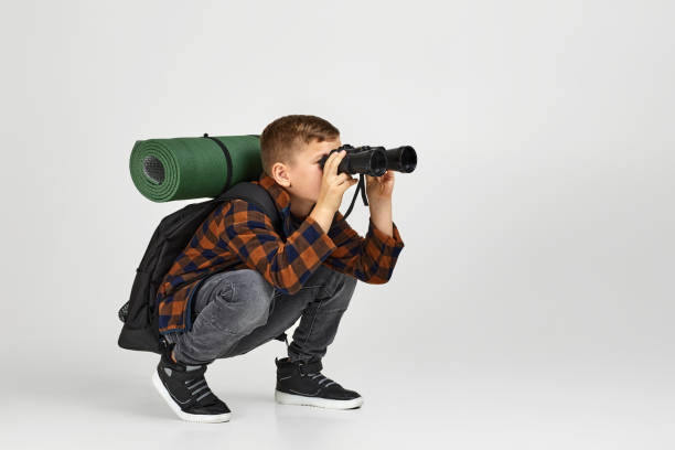 touriste de petit garçon avec des jumelles - discovery binoculars boy scout searching photos et images de collection