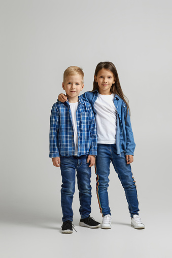 cute little boy and girl in stylish denim clothes. two happy children