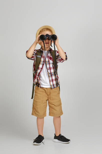 mały chłopiec turysta z plecakiem patrząc przez lornetkę. - discovery binoculars boy scout searching zdjęcia i obrazy z banku zdjęć