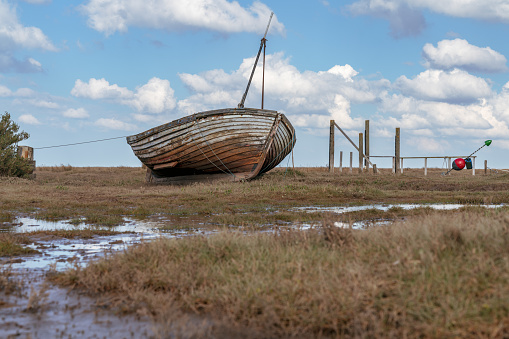 An old wooden sailing boat in Thornham Old Harbour, Norfolk, England, UK