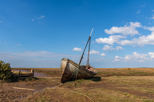 An old wooden sailing boat in Thornham Old Harbour, Norfolk, England, UK