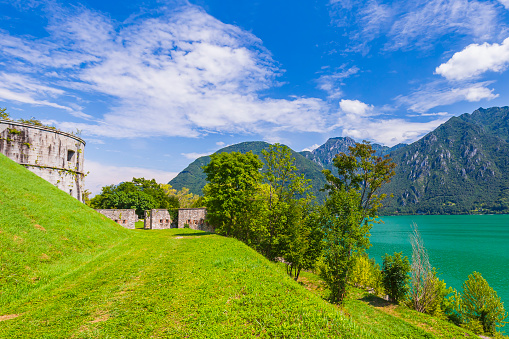 Sightseeing at the beautiful landscape of lake Idro Rocca d'Anfo Italy, ruins of a old bunker. Clouded summer day, colorful scene.