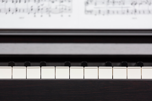 Electric piano (clavinova) keys and sheet music close-up