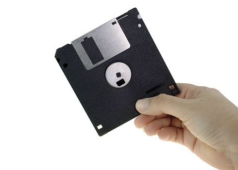 Floppy disk or diskette in human hand isolated on white background with clipping path