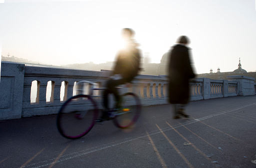 A bicycle and a passerby on the Wilson bridge in Lyon