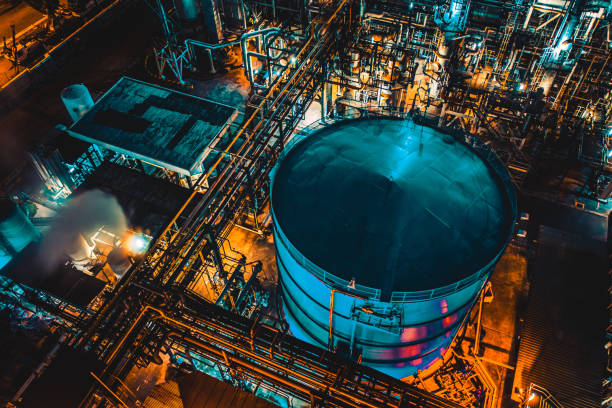 serbatoio di distillazione di un impianto di raffineria di petrolio di notte - refinery factory night petroleum foto e immagini stock