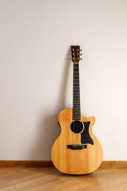 istock Acoustic guitar against the wall. 1291039559