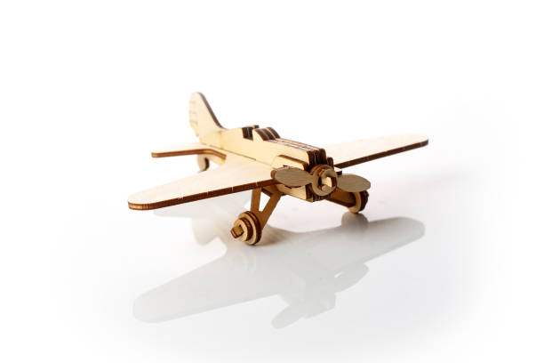 istock Small wooden airplane on a white background with reflection. 1291039565