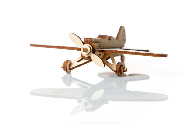 istock Small wooden airplane on a white background with reflection. 1291039570