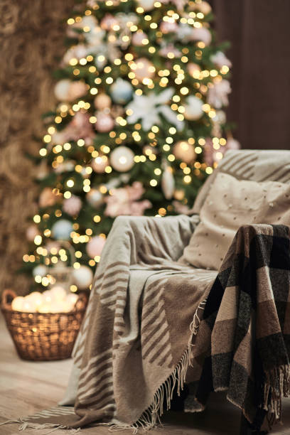 istock armchair with warm blanket and decorated Christmas tree. 1291039745