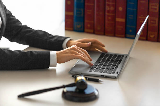 Female hands with a judge's gavel in front of a laptop monitor stock photo