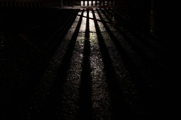 istock Shaft of light streaming through a steel gate at night 1291041575