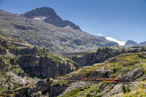 tourist train running through a mountain gorge in the Pyrenees, Artouste France, horizontal