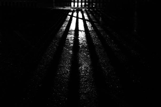 istock Shaft of light streaming through a steel gate at night 1291041674