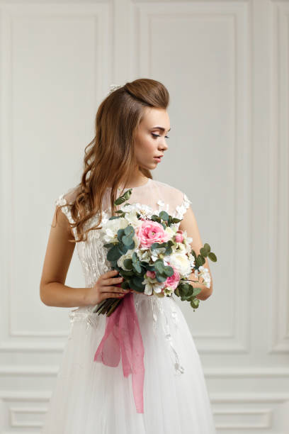 istock beautiful tender young bride with flower bouquet 1291045524