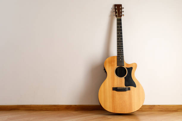 istock Acoustic guitar against the wall. 1291045878