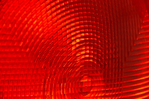 Abstract background of red faceted plastic reflective surface sign or rear lamp of taillight