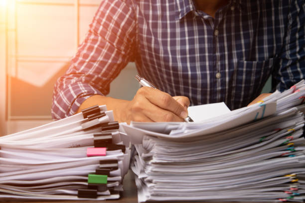 istock Business man hand pick up Stack overload document report paper with colorful paperclip, business and paperless concept. 1291046688