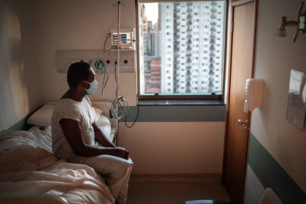 paciente senior usando máscara mirando a través de la ventana en el hospital - bed hospital prognosis patient fotografías e imágenes de stock