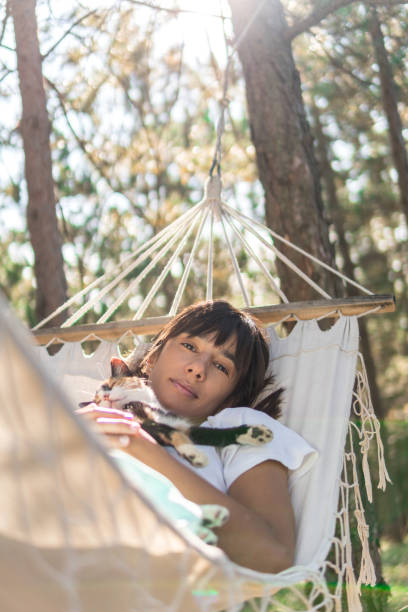 istock Women enjoy with cat in hammock 1291050233