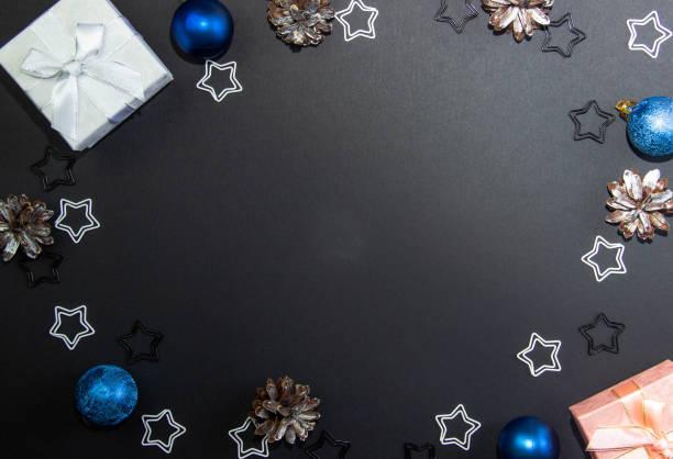 istock Beautiful Christmas layout for writing on a black background with Christmas gift boxes and Christmas decorations. View from above. Copy space 1291052372