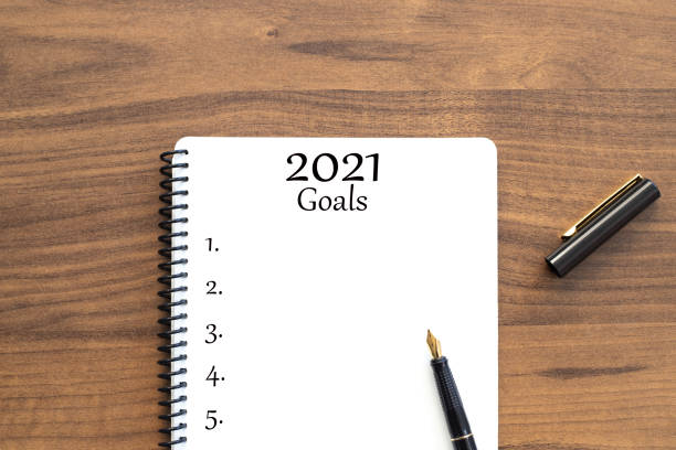 istock Note book with 2021 goals text on it to apply new year resolutions and plan. 1291052535