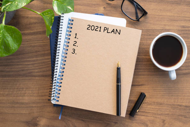 istock Note book with 2021 goals text on it to apply new year resolutions and plan. 1291052659