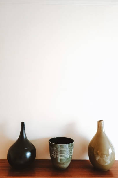 istock Three ceramic vases on a wooden shelf. 1291052891