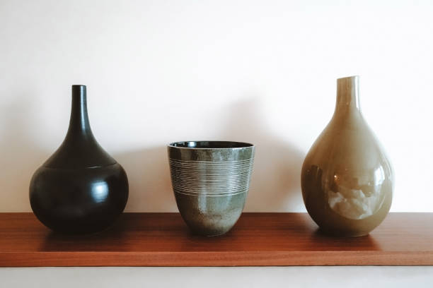 istock Three ceramic vases on a wooden shelf. 1291052902