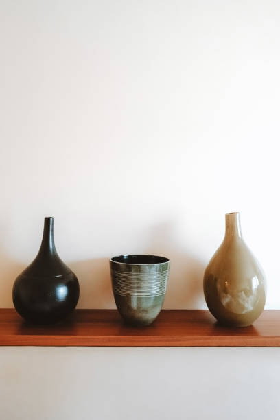 istock Three ceramic vases on a wooden shelf. 1291052915