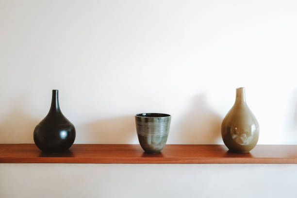 istock Three ceramic vases on a wooden shelf. 1291052934