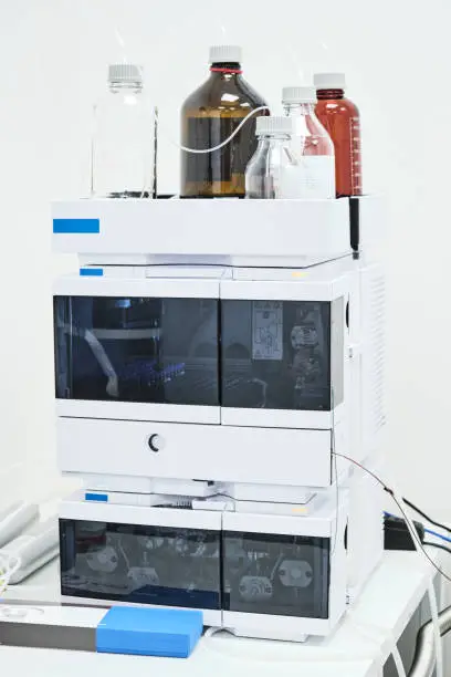 Photo of Mobile phase solvents on the HPLC system for separation of organic compounds in chemical or pharmaceutical laboratory.