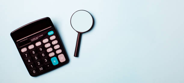 istock Magnifying glass with calculator on report.blue tone 1291057941