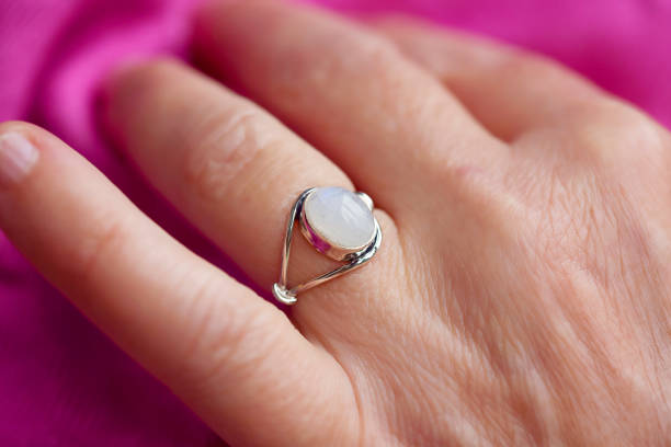 istock gem mineral silver ring on female hand with pink background 1291057967