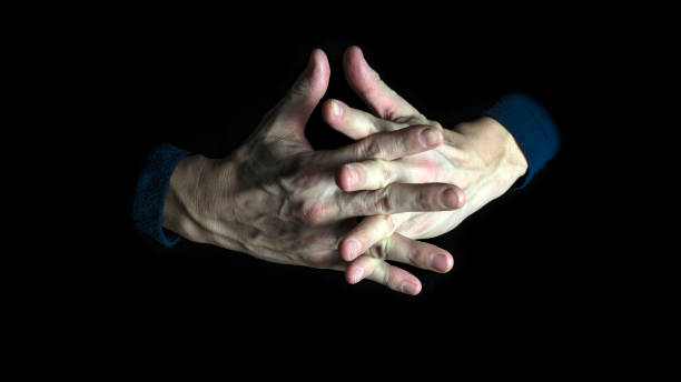 istock Man hands praying in dark background. Close up. 1291058194