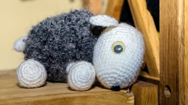istock Black sheep doll on a wooden shelf background 1291058857