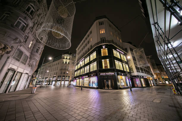 A closed Louis Vuitton store during the pandemic. VIENNA, AUSTRIA - DECEMBER 7, 2020 - Located in the heart of the city's historical center "Goldenes Quartier" hosts dozens of luxury boutiques. During the lockdown in December only pharmacies, banks, post offices, hospitals and supermarkets are allowed to stay open. The government asks people to stay at home between 20.00 and 06.00 therefore the usually busy areas are quiet. Fashion stores are suffering from a financial loss during Christmas compared to previous years. city street consumerism window display vienna stock pictures, royalty-free photos & images