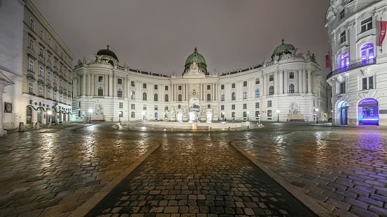 VIENNA, AUSTRIA - DECEMBER 7, 2020 - Being one of the main sights in Austria's capital the Hofburg usually attracts thousands of visitors every month. During the lockdown in December only pharmacies, banks, post offices, hospitals and supermarkets are allowed to stay open. The government asks people to remain at home between 20.00 and 06.00 therefore the usually busy areas are quiet. The building is still illuminated although there are no people in the streets.
