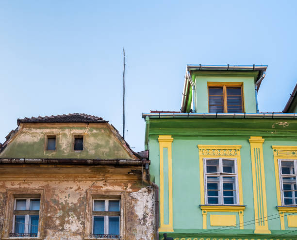 istock Two side by side old medieval buildings in Sighisoara, Romania. Restored building next to a worn out unrestored building. 1291065503