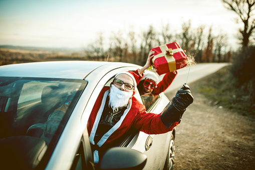 Young Santa Claus Driving A Car And Having A Fun With His Female Friend