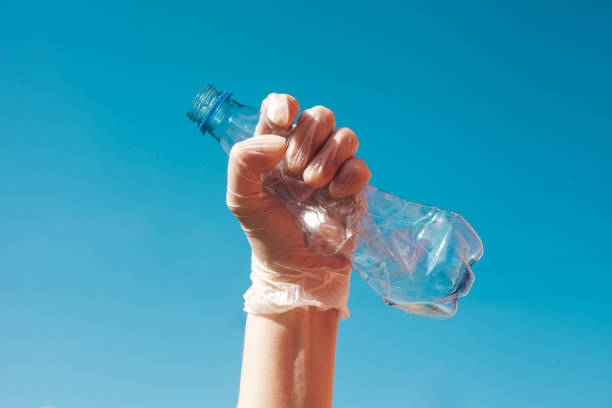 istock We are against plastic garbage. A hand in protective gloves clutches an empty disposable bottle. 1291068145