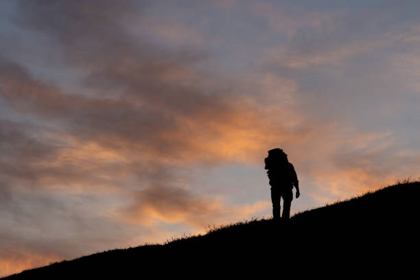 istock Man hiking into the sunset 1291068977