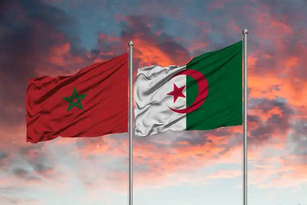 Flag of Morocco and Algeria waving together in the blue sky