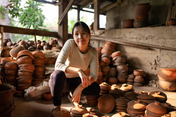 istock Female potter examining pottery in studio 1291069586