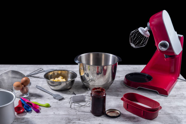 istock Work table with kneading machine plus various tools and ingredients. Home cooking and pastry concept. Selective focus 1291070299
