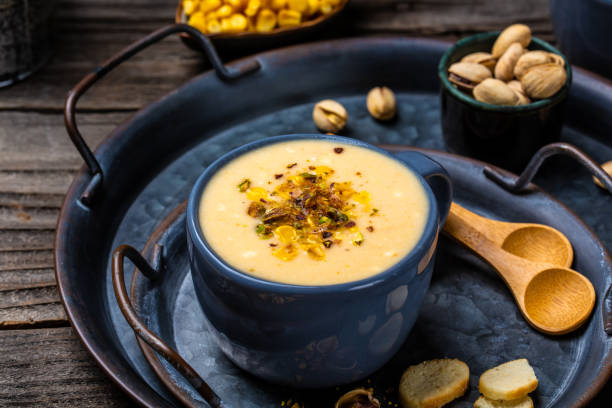 istock cheese cream soup with corn, pistachios and croutons on a rustic background. banner, catering menu recipe. top view 1291070305