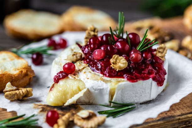 pieczona brie camembert ze świeżym rozmarynem i sosem żurawinowym. przekąska dla smakoszy. śniadanie, tło przepis żywności. z bliska. - pieczony zdjęcia i obrazy z banku zdjęć