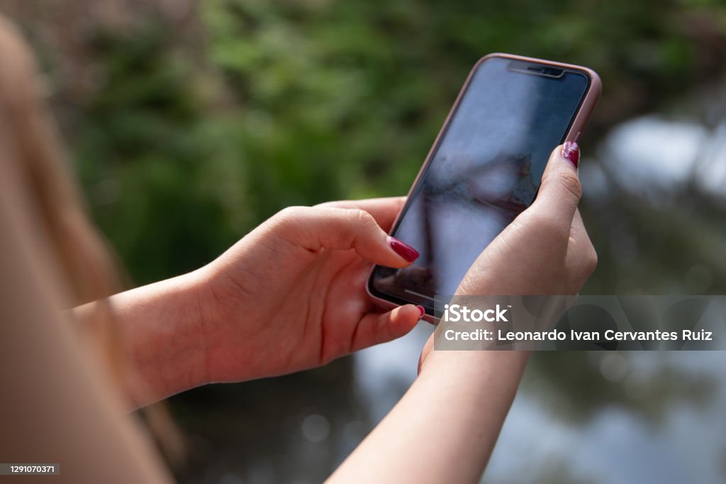 Close-up of a young woman using mobile phone Close Up Of Hands Of a young woman holding a mobile phone Adult Stock Photo