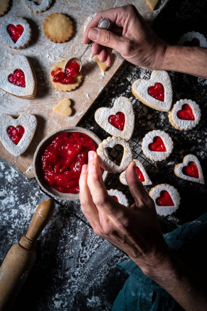 istock Linzer cookies preparation man hands put strawberry jam with spoon 1291070498