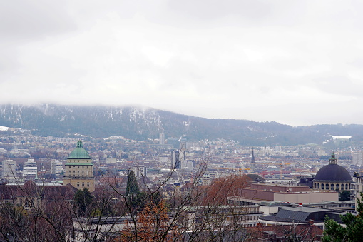 Zurich, Switzerland - 12 06 2020: Aerial view of Zurich in winter with University and Federal Institute of Technology in the foreground. Uetliberg, a mountain in the background is covered in mist.